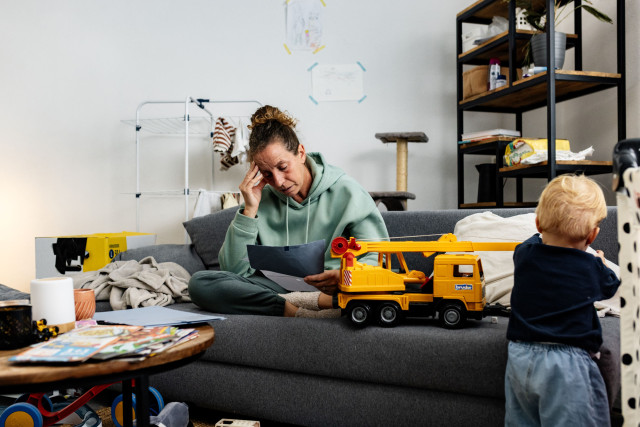 Ingrid leest een blauw envelop in de woonkamer
